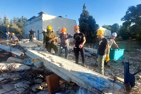 מתנדבים מצוותי הסער (סיוע עצמי ראשוני) במהלך אימון התנסות בפינוי הריסות.