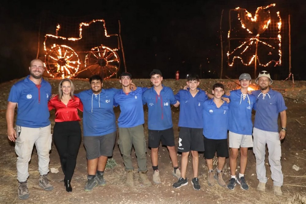 ראשת המועצה עם נוער עמק יזרעאל על רקע כתובות אש