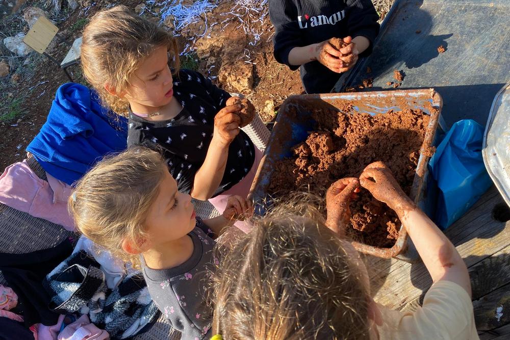 ילדים וילדות מכינים פסלי בוץ