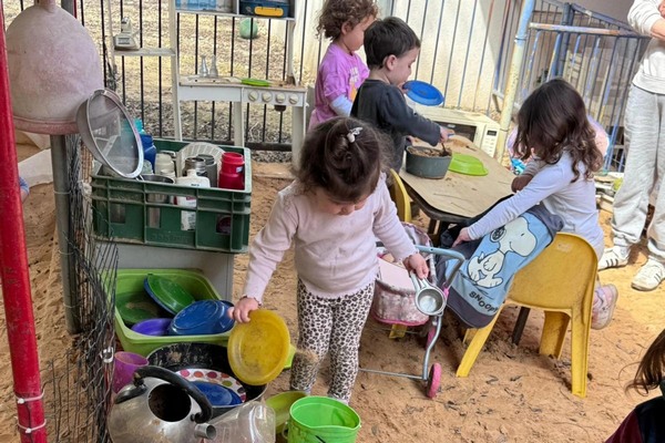 ילדים וילדות משחקים.ות בחצר הגן